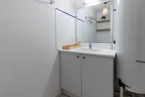 a white bathroom with a sink and a mirror at Aux Gourbets - Conciergerieland in Vieux-Boucau-les-Bains +13 photos