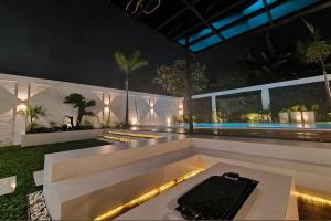 a backyard with a pool at night with a table at Mega Jaya Villa in Yogyakarta