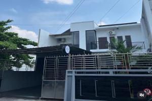 a white house with a gate in front of it at Mega Jaya Villa in Yogyakarta
