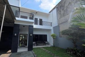 a white house with a bench in front of it at Mega Jaya Villa in Yogyakarta +21 photos