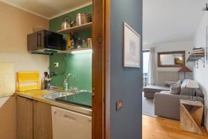 a kitchen with a sink and a living room at Relax At The Mountain in Madonna di Campiglio