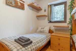 a small bedroom with a bed and a dresser at Relax At The Mountain in Madonna di Campiglio