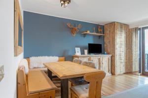 a living room with a wooden table and a tv at Relax At The Mountain in Madonna di Campiglio