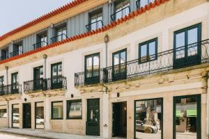 a building with windows and balconies on a street at Torel Saboaria in Porto