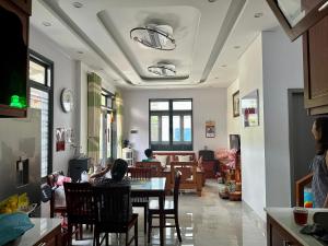 a woman sitting at a table in a dining room at Quỳnh s House in Tân Hiệp