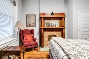 a bedroom with a bed and a chair and a fireplace at Carytown nest King Bed fully fenced in Richmond