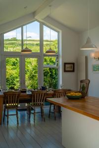 a dining room with a table and chairs and windows at Chuggs Orchard in Croyde