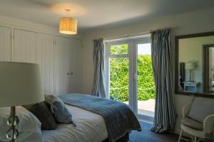 a bedroom with a bed and a sliding glass door at Chuggs Orchard in Croyde