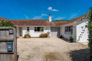a house with a gravel driveway in front of it at Chuggs Orchard in Croyde