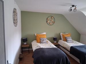 two beds in a room with green walls at Gîte La Belle du Clocher in Saint-Pardoux-dʼArnet