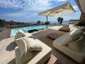 ein Wohnzimmer mit weißen Möbeln und ein Swimmingpool in der Unterkunft Villa Ormalute in Pozzuoli