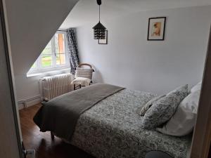 a bedroom with a bed and a window at Gîte La Belle du Clocher in Saint-Pardoux-dʼArnet
