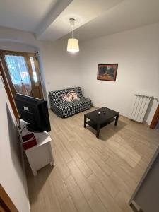 a living room with a couch and a tv at Appartamenti La Quiete in Mele