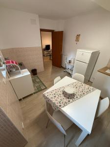 a kitchen with a table and a white refrigerator at Appartamenti La Quiete in Mele