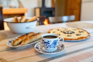 a table with a cup of coffee and a pizza at Apartmán U babičky in Strakonice