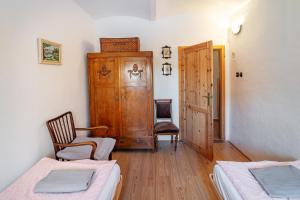 a room with two beds and a chair and a door at Apartmán U babičky in Strakonice +23 photos
