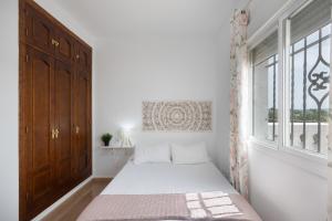 a small bedroom with a bed and a window at Casa Familiar La Lobita 2 in Conil de la Frontera +23 photos
