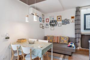 a dining room with a table and a couch at Villa Benaco in Pozzolengo