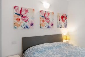 a bedroom with three paintings on the wall at Villa Benaco in Pozzolengo +17 photos