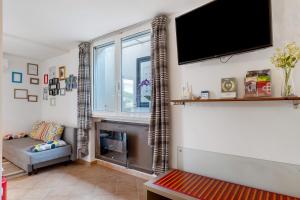 a living room with a fireplace and a flat screen tv at Villa Benaco in Pozzolengo