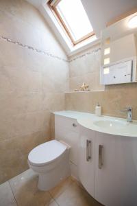 a bathroom with a toilet and a sink and a skylight at Ty Haf in Rhosneigr +45 photos