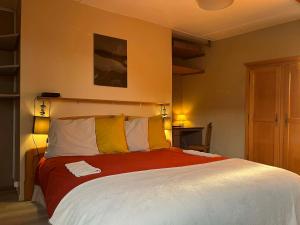 a bedroom with a large bed with yellow and white pillows at Aux 10 Ponts Maison spacieuse et conviviale au bord de la Somme la mer à 30 min 6 personnes in Pont-Rémy