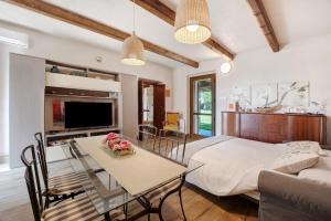 a living room with a bed and a table with flowers on it at Cascina Brignolo - Casa Bianca in Novara