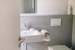 a bathroom with a white sink and a toilet at HeartArt 2 in Bad Münstereifel +15 photos