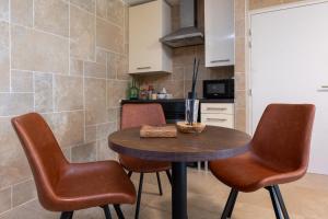 a kitchen with a wooden table and two chairs at Sensori Nuit in Grand-Champ