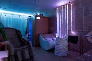 a room with a couch and a bed with lights at Sensori Nuit in Grand-Champ