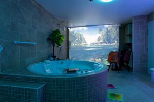 a bathroom with a tub with a large window at Sensori Nuit in Grand-Champ