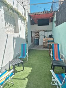 a patio with lawn chairs and a tv on a building at Nomad Hostel - Vila Madalena in São Paulo