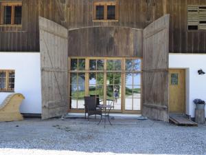 a room with a chair in front of a building at Ferienhof Forstmoar in Gars am Inn