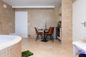 a bathroom with a table and chairs and a tub at Sensori Nuit in Grand-Champ +14 photos