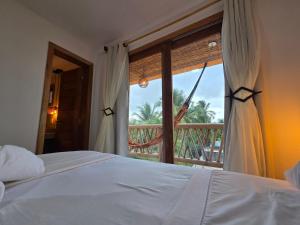 a bedroom with a bed and a window with a view at Casa Ilhéus Pousada in Ilhéus +23 photos
