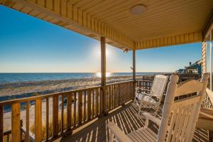 a porch with two chairs and the beach at Lady Dune in Oak Island