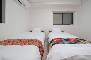 two beds in a room with white walls at the UNIT5 HOUSE Roppongi in Tokyo +77 photos