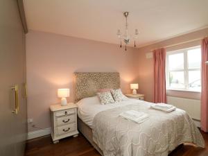 a bedroom with a bed with two lamps and a window at Sunnyside in Riverchapel