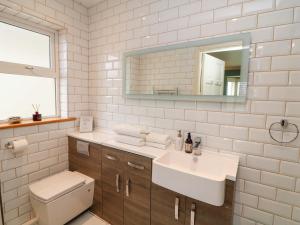 a bathroom with a sink and a toilet and a mirror at Sunnyside in Riverchapel +23 photos