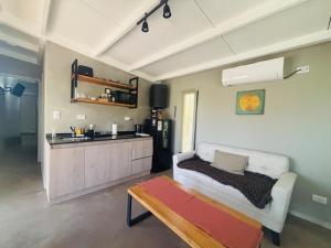 a living room with a couch and a kitchen at Rincón Sereno Tunuyán LODGE 1 in Tunuyán