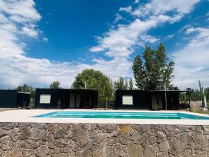 a swimming pool in a building with a stone wall at Rincón Sereno Tunuyán LODGE 1 in Tunuyán
