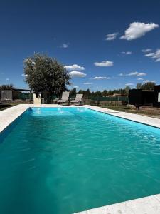 a swimming pool with blue water at Rincón Sereno Tunuyán LODGE 1 in Tunuyán +9 photos