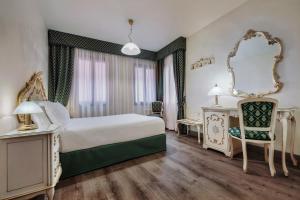 a bedroom with a bed and a mirror and a chair at Hotel Commercio & Pellegrino in Venice