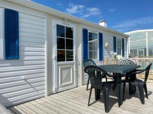 a patio with a table and chairs on a deck at Camping Les 2 Plages in Quend