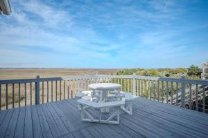 a white table and chairs on a wooden deck at Late For The Sky in Caswell Beach