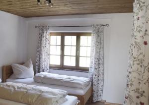 two beds in a room with a window at Ferienhof Forstmoar in Gars am Inn