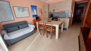 a living room with a couch and a table and a kitchen at Residence degli ulivi in Ossi