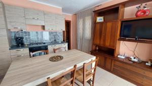a kitchen with a wooden table with a television and a dining room at Residence degli ulivi in Ossi