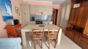 a kitchen with a table and chairs in a room at Residence degli ulivi in Ossi
