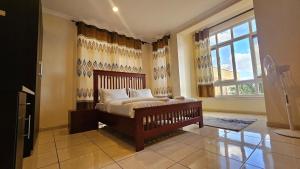a bedroom with a bed and a large window at JJ Comfort Homes in Arusha +43 photos
